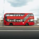 Red city bus driving on a road